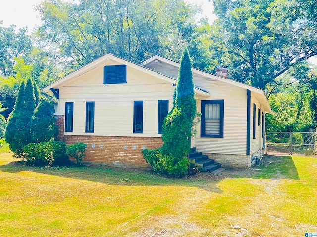 view of side of home with a yard