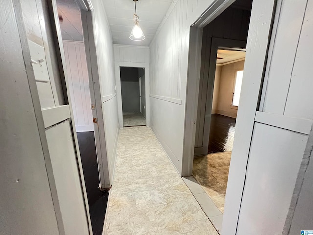 corridor featuring ornamental molding and wooden walls