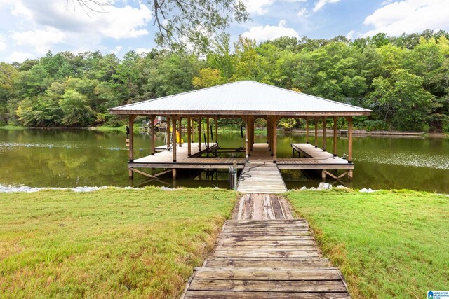 dock area featuring a water view and a lawn