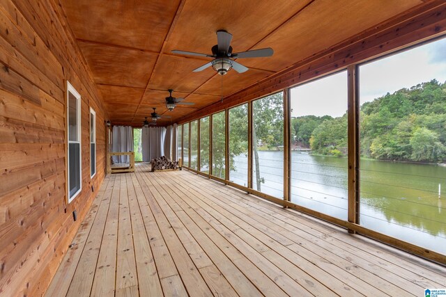 unfurnished sunroom with ceiling fan, wooden ceiling, and a water view