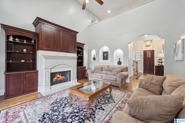 living room with high vaulted ceiling, light wood-type flooring, ceiling fan, and beamed ceiling