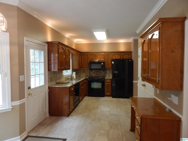 kitchen with light stone countertops, black appliances, tasteful backsplash, ornamental molding, and sink