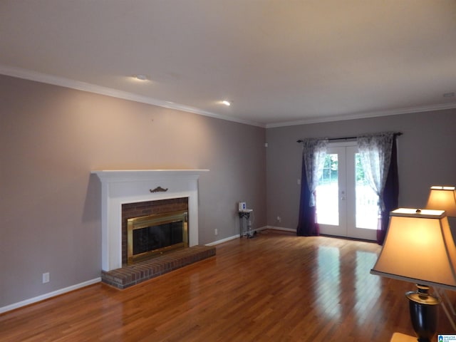 unfurnished living room with french doors, ornamental molding, a brick fireplace, and hardwood / wood-style flooring