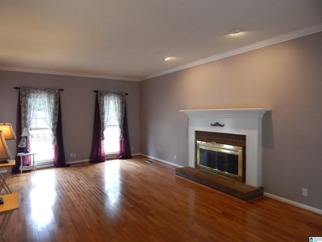 unfurnished living room featuring ornamental molding, hardwood / wood-style flooring, and a fireplace