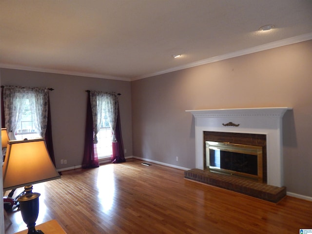 unfurnished living room with a fireplace, crown molding, a healthy amount of sunlight, and wood-type flooring