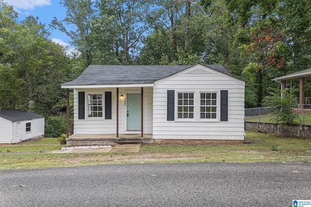 view of front of property with a storage shed and a porch