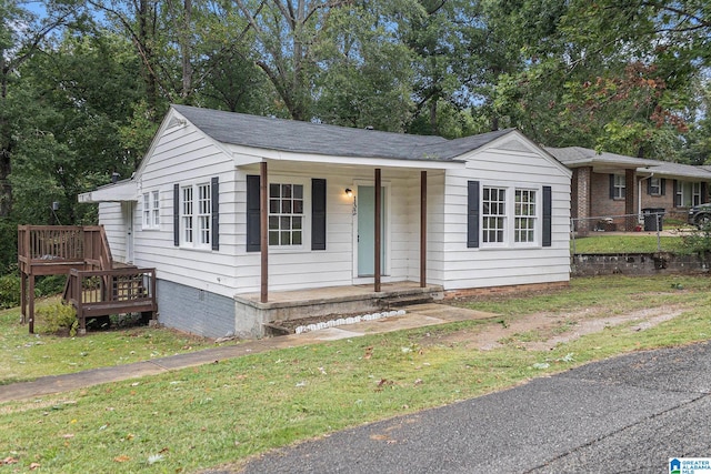 view of front of property featuring a front yard and a wooden deck