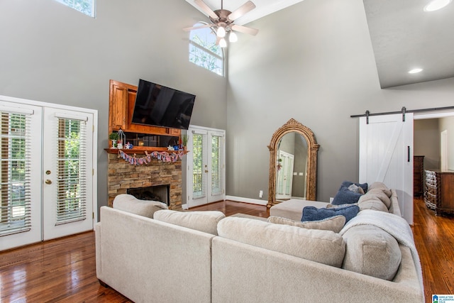 157 Hickory Ridge Dr, Glencoe, AL 35905 - living area with a high ceiling, a barn door, ceiling fan, dark wood-type flooring, and healthy amount of natural light