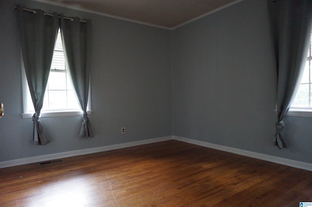 spare room with crown molding and dark hardwood / wood-style flooring