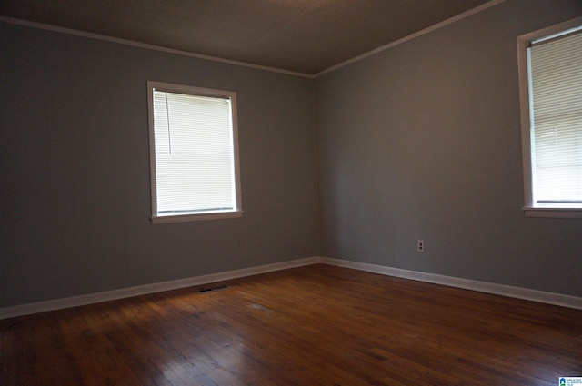 unfurnished room featuring ornamental molding and dark hardwood / wood-style flooring