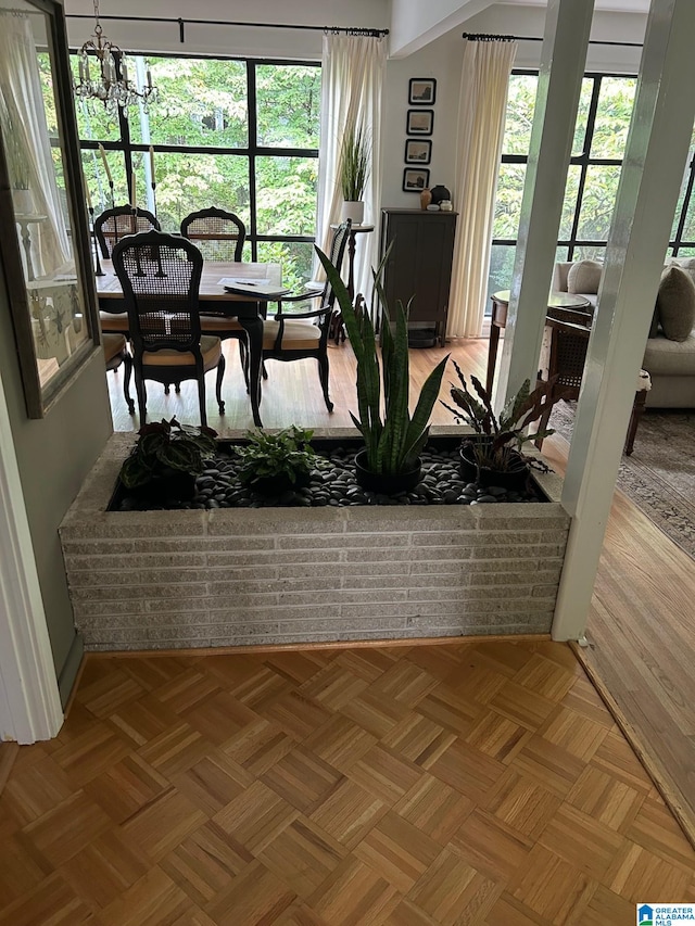 dining space with parquet floors, a healthy amount of sunlight, and an inviting chandelier