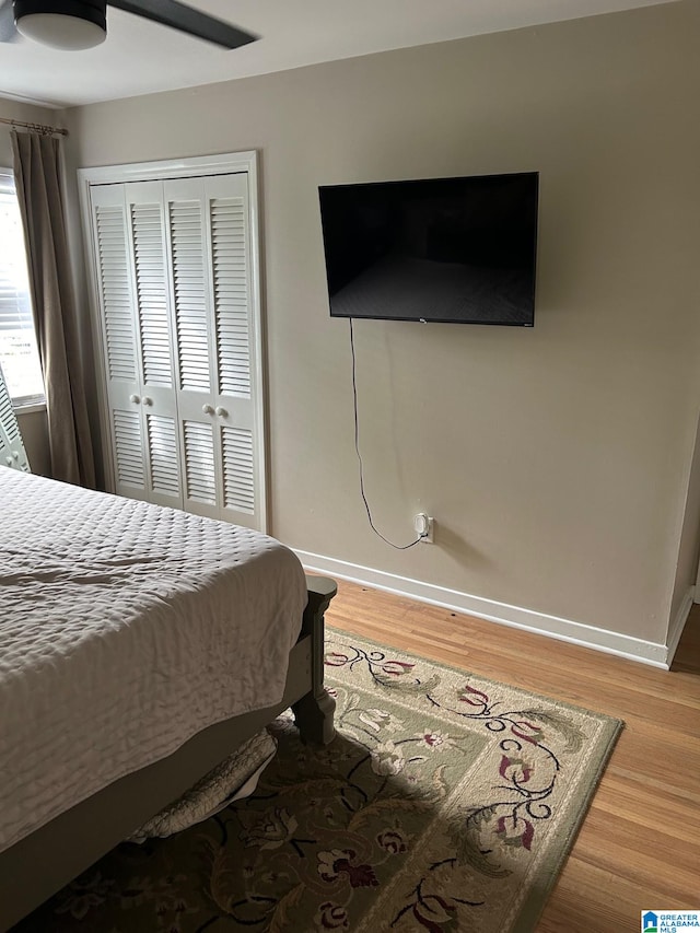 bedroom featuring wood-type flooring, a closet, and ceiling fan