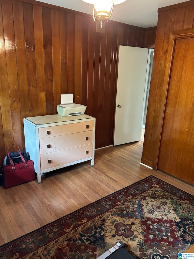 bedroom featuring wood walls and light hardwood / wood-style floors