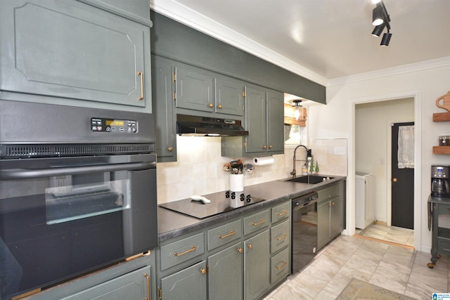 kitchen with tasteful backsplash, ornamental molding, washer and clothes dryer, sink, and black appliances