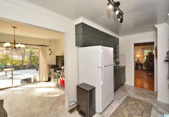 kitchen featuring white fridge, light wood-type flooring, ornamental molding, and an inviting chandelier