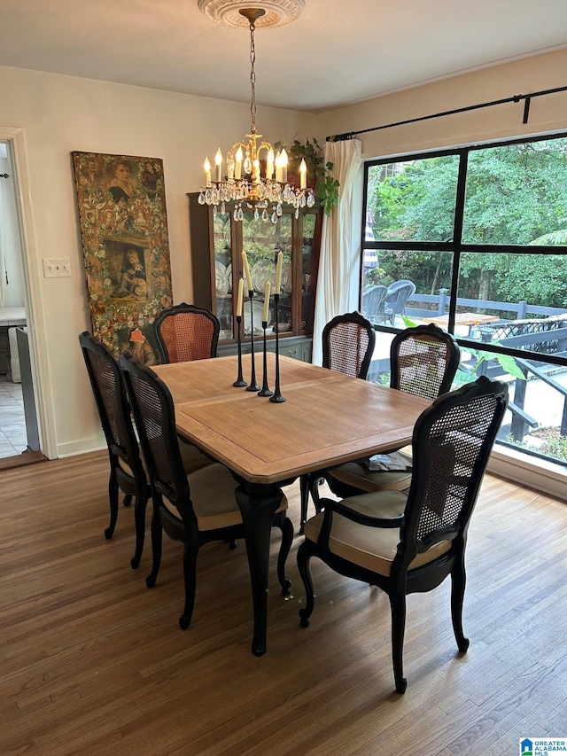 dining space with hardwood / wood-style floors, a notable chandelier, and a wealth of natural light