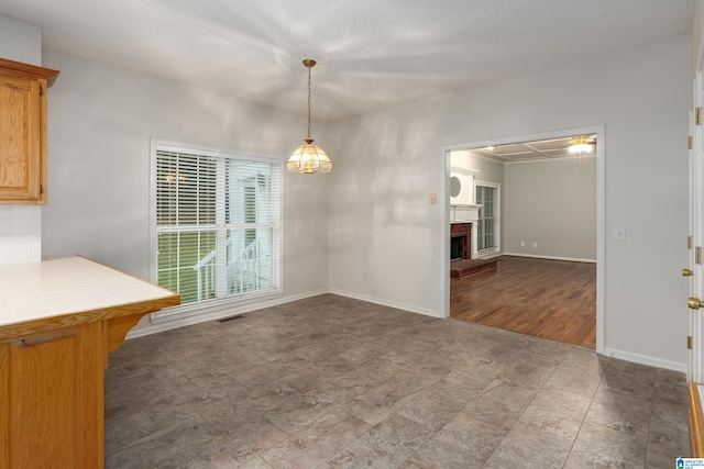 unfurnished dining area with a brick fireplace and wood-type flooring