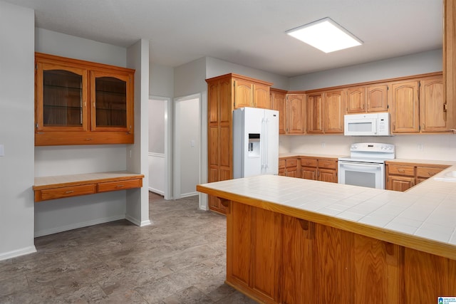 kitchen featuring tile counters, white appliances, and kitchen peninsula