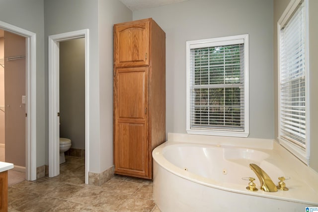 bathroom featuring tile patterned floors, a textured ceiling, a tub, and toilet