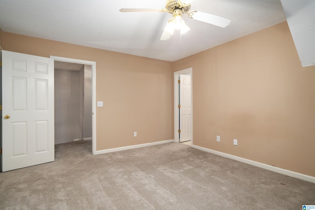 unfurnished bedroom with ceiling fan, a textured ceiling, and light carpet