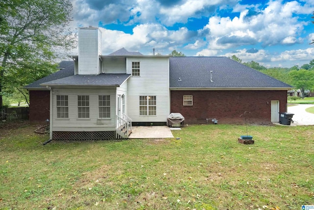 back of property featuring a lawn and a patio