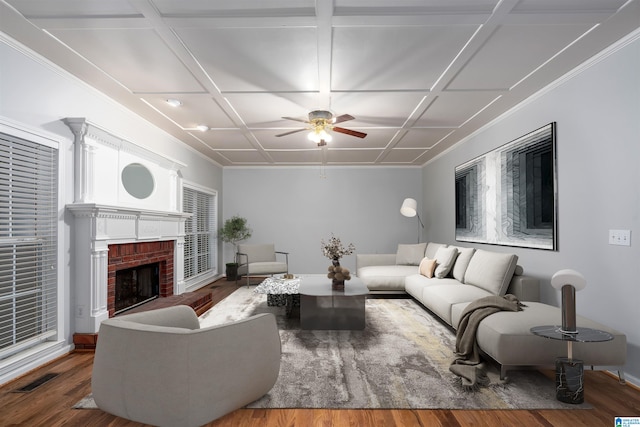 living room with wood-type flooring, coffered ceiling, ceiling fan, and a brick fireplace