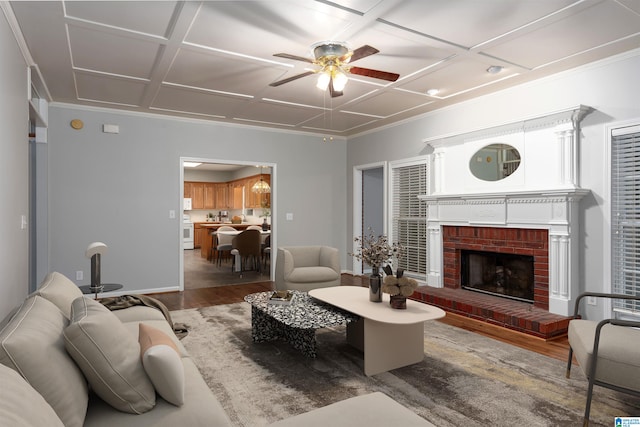 living room featuring coffered ceiling, hardwood / wood-style floors, ceiling fan, and a brick fireplace