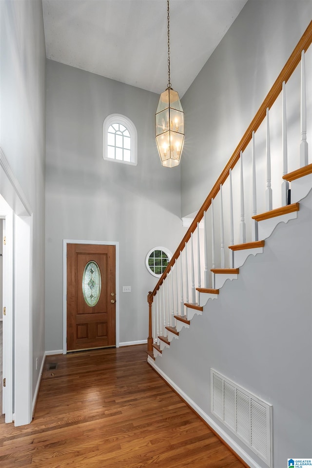 foyer featuring an inviting chandelier, a high ceiling, and hardwood / wood-style floors