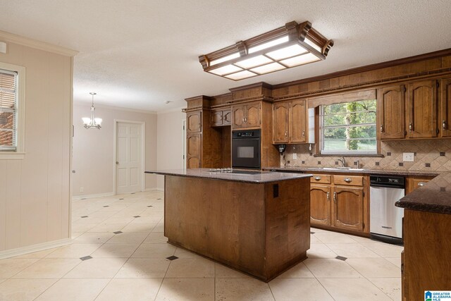 kitchen featuring a textured ceiling, a notable chandelier, a kitchen island, oven, and decorative light fixtures