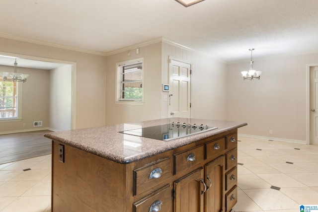 kitchen with black electric stovetop, decorative light fixtures, a center island, an inviting chandelier, and crown molding