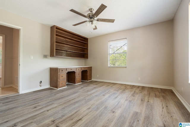 unfurnished office featuring baseboards, light wood-style floors, and ceiling fan