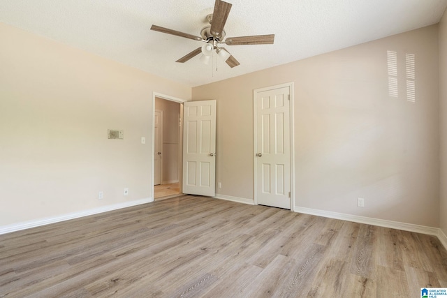 unfurnished bedroom with ceiling fan, a textured ceiling, and light wood-type flooring