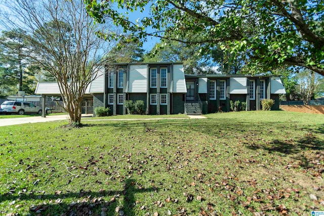 raised ranch featuring a carport and a front yard