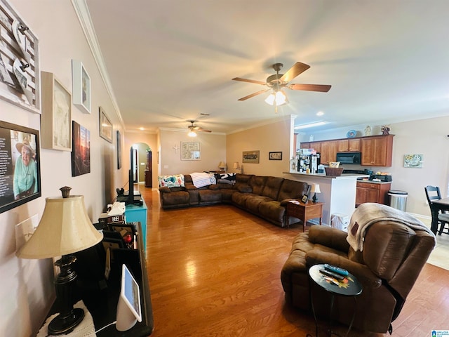 living room featuring light wood-type flooring, ornamental molding, and ceiling fan