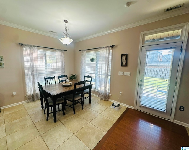 dining space featuring light wood-type flooring and ornamental molding