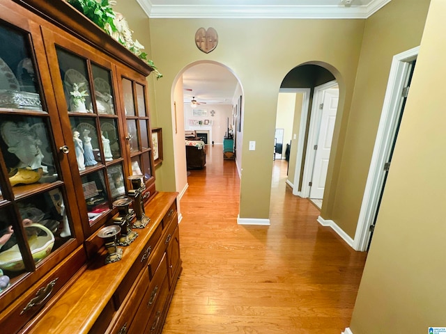 hall featuring ornamental molding and light hardwood / wood-style floors