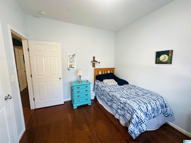 bedroom with dark wood-type flooring