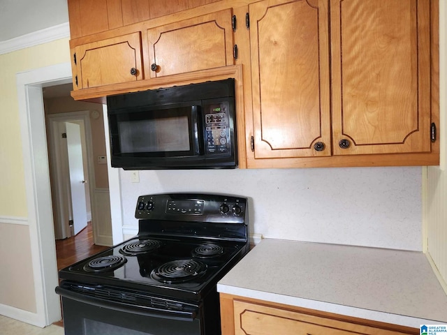 kitchen featuring black appliances and crown molding