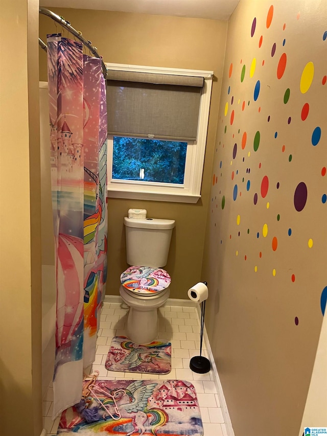 bathroom featuring tile patterned flooring, toilet, and a shower with curtain