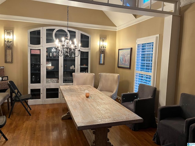 dining room featuring lofted ceiling, wood-type flooring, a chandelier, and crown molding