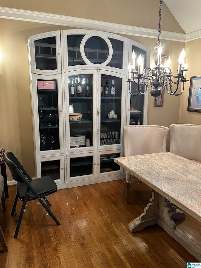 dining space featuring wood-type flooring, crown molding, and a chandelier