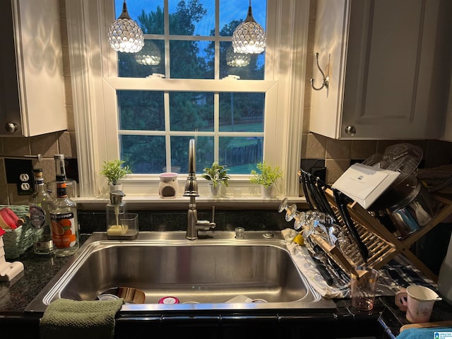 kitchen featuring hanging light fixtures, decorative backsplash, and sink