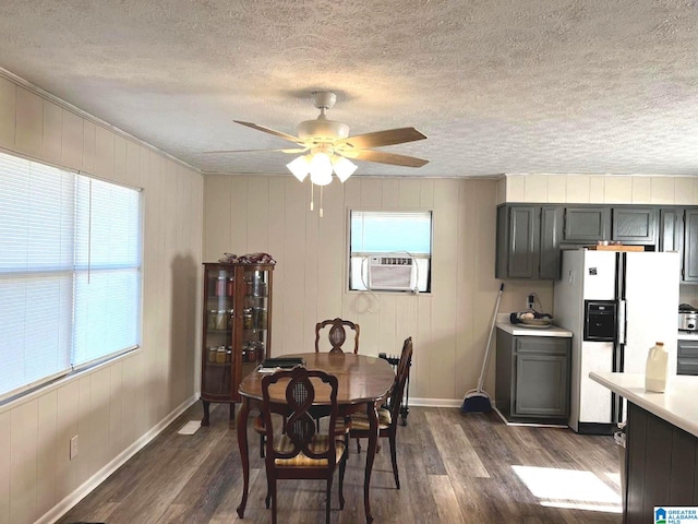 dining area with a textured ceiling, ceiling fan, plenty of natural light, and dark hardwood / wood-style flooring