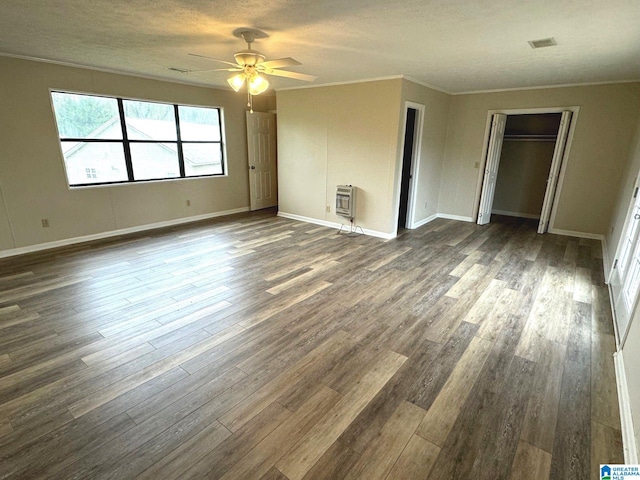 unfurnished room with ceiling fan, heating unit, dark hardwood / wood-style floors, and a textured ceiling