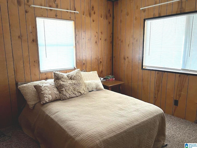 carpeted bedroom featuring wooden walls