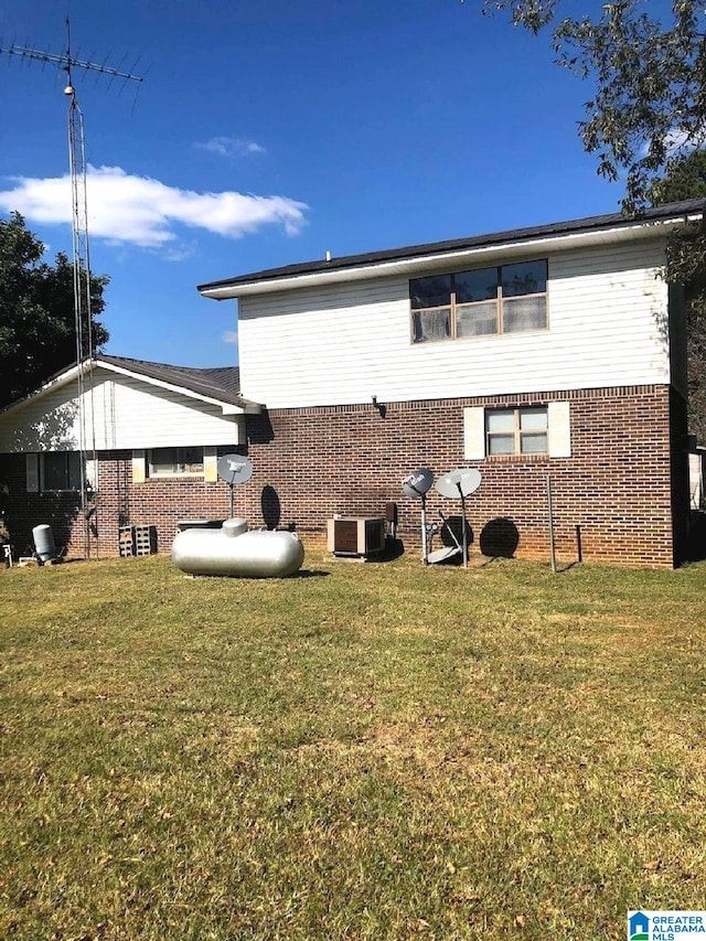 rear view of property with a lawn and cooling unit