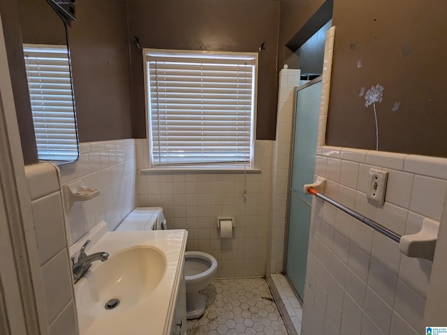 bathroom featuring vanity, toilet, walk in shower, tile walls, and tile patterned flooring