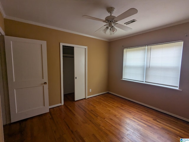 unfurnished bedroom featuring ornamental molding, wood-type flooring, and ceiling fan