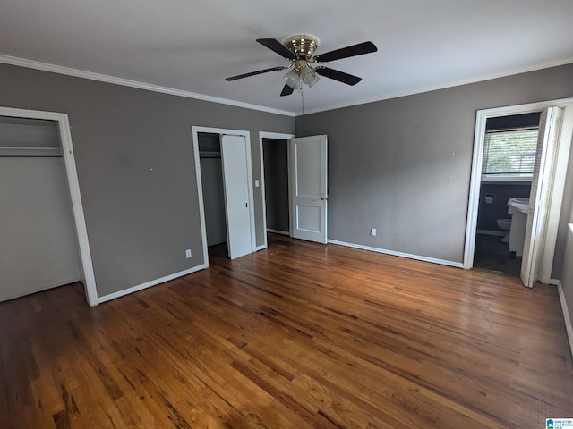 unfurnished bedroom with dark hardwood / wood-style flooring, ceiling fan, ensuite bathroom, ornamental molding, and two closets