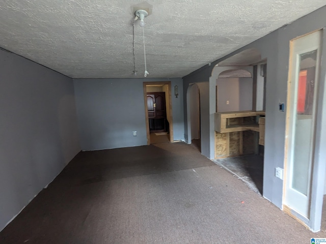 carpeted spare room featuring a textured ceiling